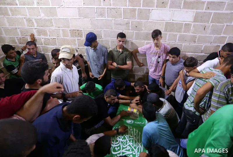 Mourners gather around the body of Palestinian Hamas militant Ahmed Albassous who was killed in Israeli tank fire, during his funeral at Omari Mosque in Gaza City July 26, 2018. Photo by Ashraf Amra