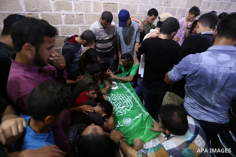 Mourners gather around the body of Palestinian Hamas militant Ahmed Albassous who was killed in Israeli tank fire, during his funeral at Omari Mosque in Gaza City July 26, 2018. Photo by Ashraf Amra