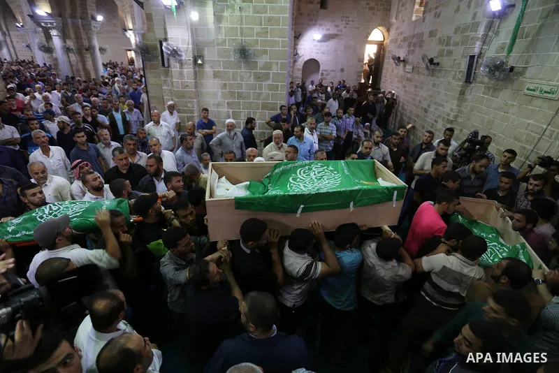 Mourners carry the bodies of Palestinian Hamas militants who were killed in Israeli tank fire, during their funeral at Omari Mosque in Gaza City July 26, 2018. Photo by Ashraf Amra