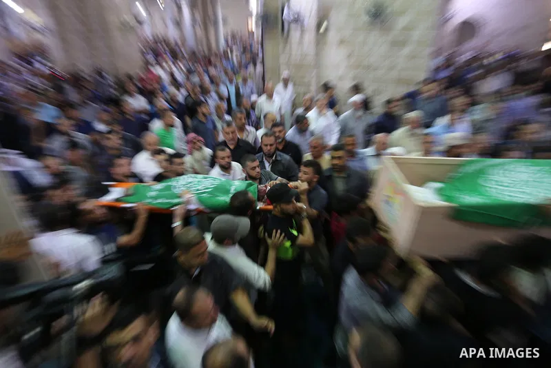 Mourners carry the bodies of Palestinian Hamas militants who were killed in Israeli tank fire, during their funeral at Omari Mosque in Gaza City July 26, 2018. Photo by Ashraf Amra