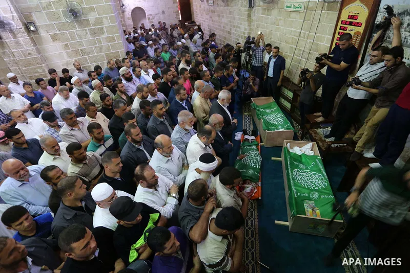 Mourners pray on the bodies of Hamas militants who were killed in Israeli tank fire, during their funeral l at Omari Mosque in Gaza City July 26, 2018. Photo by Ashraf Amra