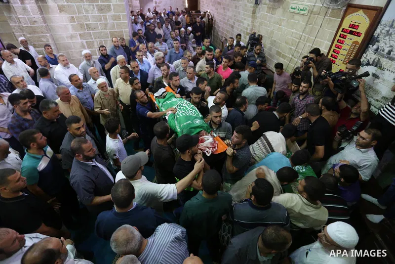 Mourners carry the bodies of Palestinian Hamas militants who were killed in Israeli tank fire, during their funeral in Gaza City July 26, 2018. Photo by Ashraf Amra
