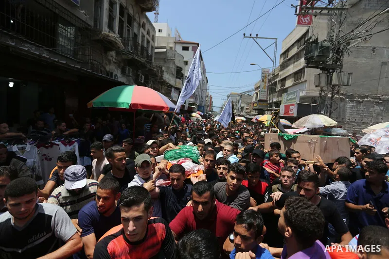 Mourners carry the bodies of Palestinian Hamas militants who were killed in Israeli tank fire, during their funeral in Gaza City July 26, 2018. Photo by Ashraf Amra