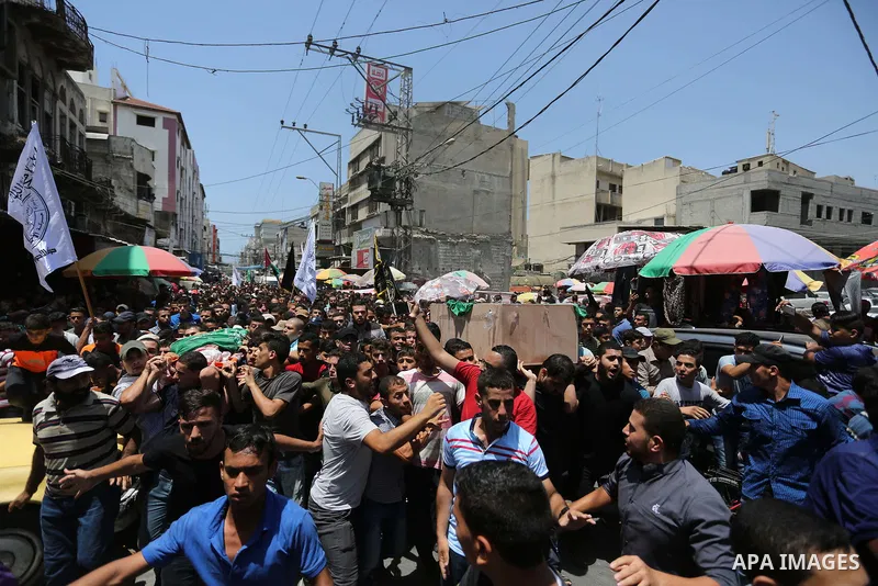 Mourners carry the bodies of Palestinian Hamas militants who were killed in Israeli tank fire, during their funeral in Gaza City July 26, 2018. Photo by Ashraf Amra