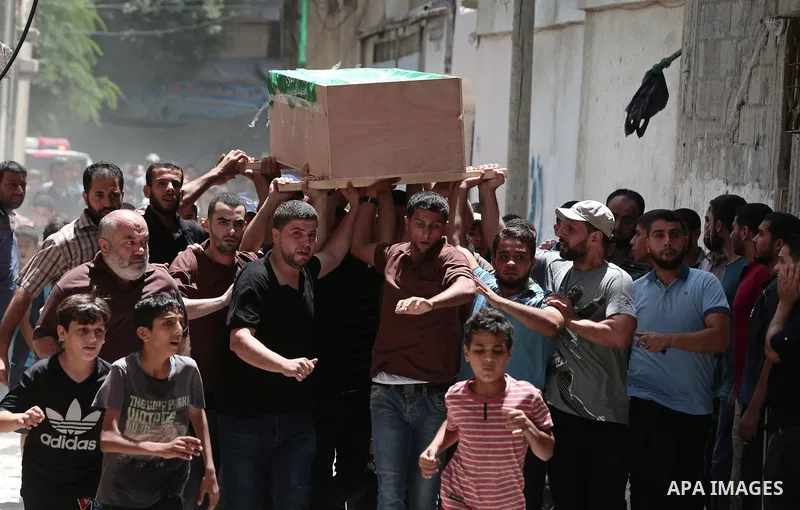Mourners carry the body of Palestinian Hamas militant Obada Farwana, who was killed in Israeli tank fire, during his funeral in Gaza City on July 26, 2018. Photo by Ashraf Amra