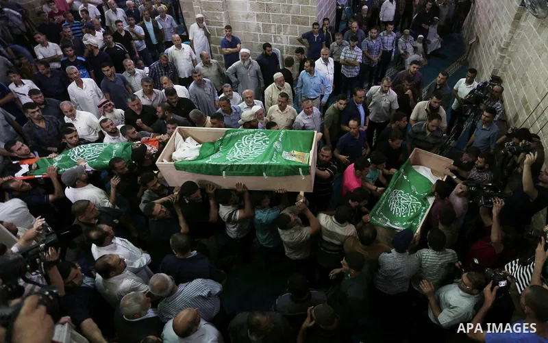Mourners carry the bodies of Palestinian Hamas militants who were killed in Israeli tank fire, during their funeral at Omari Mosque in Gaza City July 26, 2018. Photo by Ashraf Amra