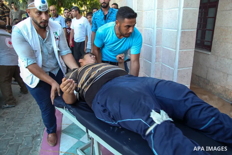 A Palestinian who was wounded during clashes with Israeli troops at Gaza-Israel border is carried on stretcher outside a hospital, in Jabalia in the northern of Gaza Strip on July 27, 2018. Photo by Ramez Habboub