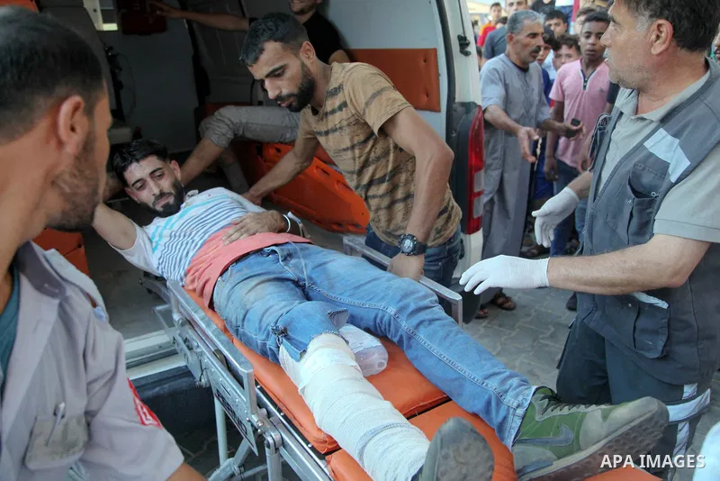 A Palestinian who was wounded during clashes with Israeli troops at Gaza-Israel border is carried on stretcher outside a hospital, in Jabalia in the northern of Gaza Strip on July 27, 2018. Photo by Ramez Habboub
