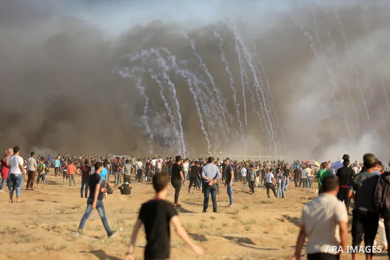 Palestinian protesters gather during clashes with Israeli troops in tents protest where Palestinian demand the right to return to their homeland at the Israel-Gaza border, in east of Gaza City on July 27, 2018. Photo by...