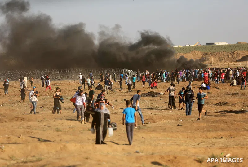 Palestinian protesters gather during clashes with Israeli troops in tents protest where Palestinian demand the right to return to their homeland at the Israel-Gaza border, in east of Gaza City on July 27, 2018. Photo by...