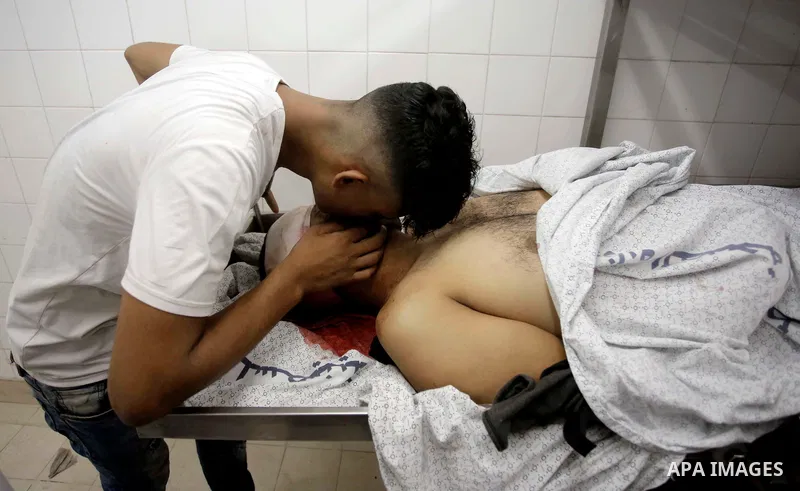 Relatives of Palestinian Ghazi Abu Mustafa, 43, who was shot dead by Israeli troops during clashes at Gaza-Israel border mourn over his body at a morgue in a hospital in Khan Younis in the southern of Gaza Strip on July...