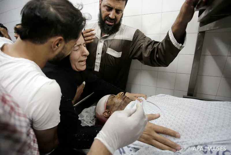 Relatives of Palestinian Ghazi Abu Mustafa, 43, who was shot dead by Israeli troops during clashes at Gaza-Israel border mourn over his body at a morgue in a hospital in Khan Younis in the southern of Gaza Strip on July...