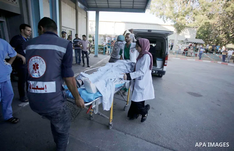 A Palestinian who was wounded during clashes with Israeli troops at Gaza-Israel border is carried on stretcher outside a hospital, in Khan Younis in the southern of Gaza Strip on July 27, 2018. Photo by Ramadan Elagha