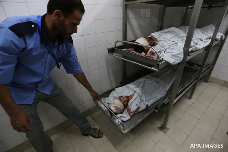 A medic stands over the bodies of 11-year-old Majdi Al-Sutari and 43-year-old Ghazi Abu Mustafa, who were killed during a demonstration along the border between Israel and the Gaza strip, at the morgue of the European Ho...