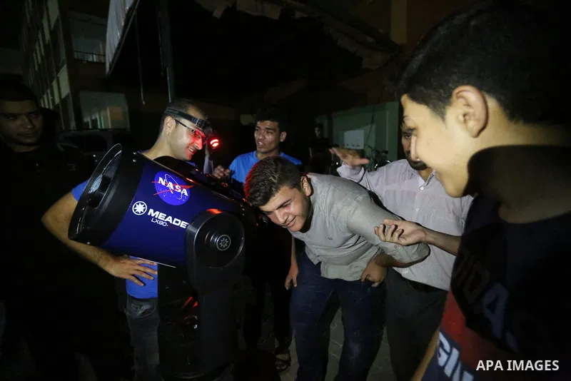 Palestinians inspect the total lunar eclipse by a telescope in the sky of Khan Younis in the southern of Gaza Strip on July 27, 2018. The longest "blood moon" eclipse this century began on July 27, coinciding with Mars'...