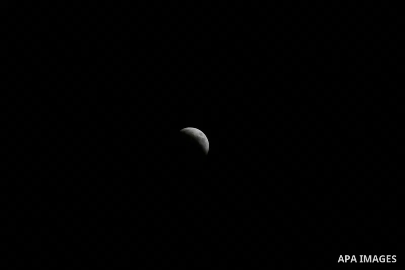 This picture shows the moon during the total lunar eclipse in the sky of Khan Younis in the southern of Gaza Strip on July 27, 2018. The longest "blood moon" eclipse this century began on July 27, coinciding with Mars' c...
