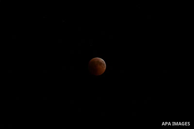 This picture shows the moon during the total lunar eclipse in the sky of Khan Younis in the southern of Gaza Strip on July 27, 2018. The longest "blood moon" eclipse this century began on July 27, coinciding with Mars' c...