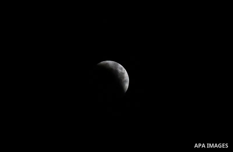 This picture shows the moon during the total lunar eclipse in the sky of Khan Younis in the southern of Gaza Strip on July 27, 2018. The longest "blood moon" eclipse this century began on July 27, coinciding with Mars' c...