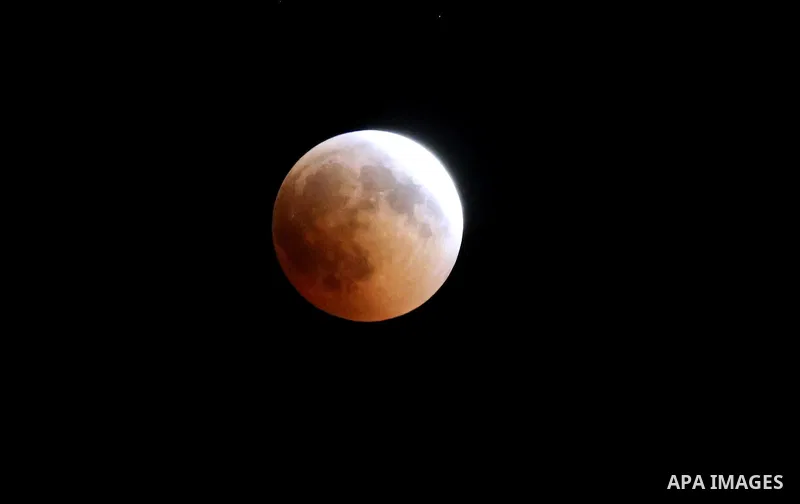 This picture shows the moon during the total lunar eclipse in the sky of Khan Younis in the southern of Gaza Strip on July 27, 2018. The longest "blood moon" eclipse this century began on July 27, coinciding with Mars' c...