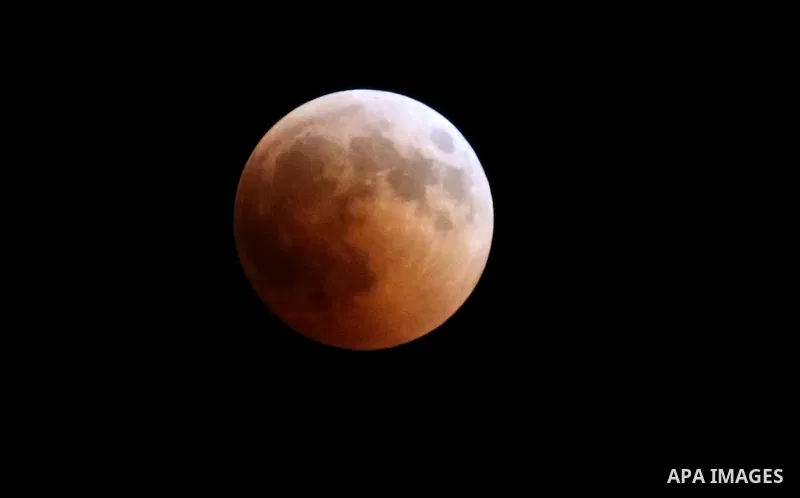 This picture shows the moon during the total lunar eclipse in the sky of Khan Younis in the southern of Gaza Strip on July 27, 2018. The longest "blood moon" eclipse this century began on July 27, coinciding with Mars' c...