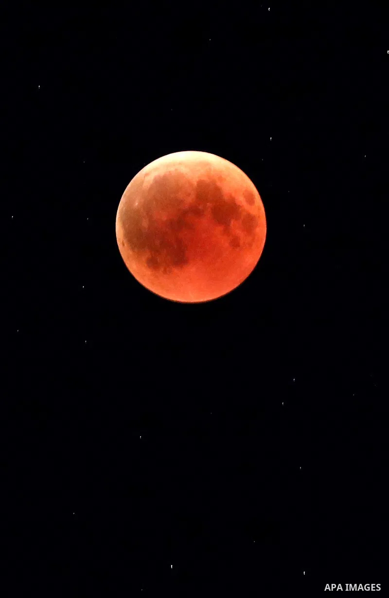 This picture shows the moon during the total lunar eclipse in the sky of the West Bank city of Hebron on July 27, 2018. The longest "blood moon" eclipse this century began on July 27, coinciding with Mars' closest approa...