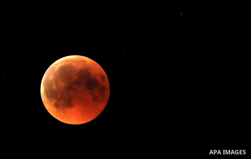 This picture shows the moon during the total lunar eclipse in the sky of the West Bank city of Hebron on July 27, 2018. The longest "blood moon" eclipse this century began on July 27, coinciding with Mars' closest approa...