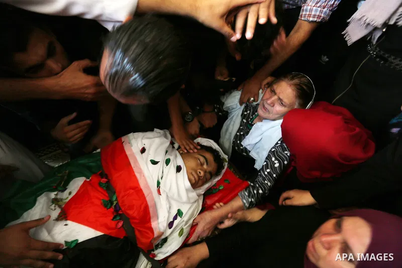 Relatives of Palestinian Mohmen al-Hams, 17, who died of wounds after being shot by Israeli troops during clashes along the border the previous day mourn over his body during his funeral in the Rafah refugee camp in the...