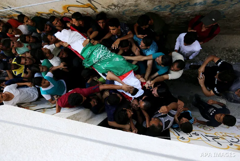 Relatives of Palestinian Mohmen al-Hams, 17, who died of wounds after being shot by Israeli troops during clashes along the border the previous day carry his body during his funeral in the Rafah refugee camp in the south...