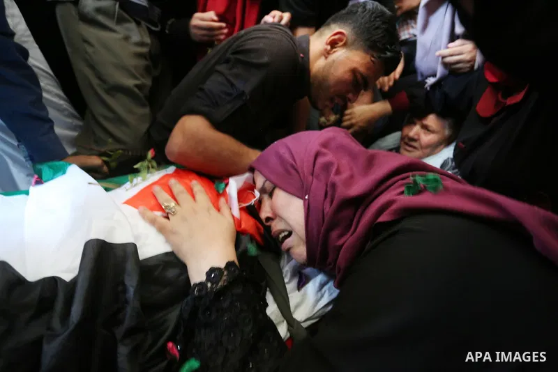 Relatives of Palestinian Mohmen al-Hams, 17, who died of wounds after being shot by Israeli troops during clashes along the border the previous day mourn over his body during his funeral in the Rafah refugee camp in the...