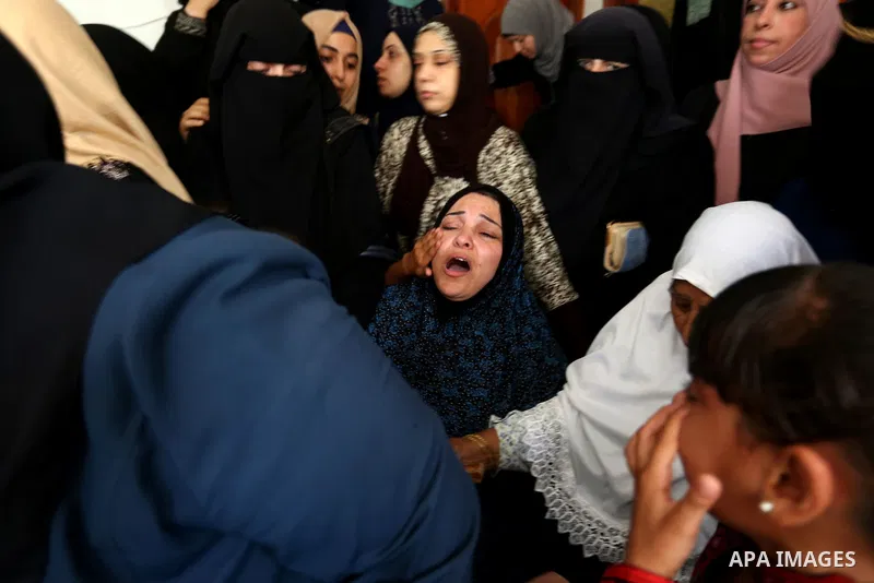 Relatives of Palestinian Mohmen al-Hams, 17, who died of wounds after being shot by Israeli troops during clashes along the border the previous day mourn during his funeral in the Rafah refugee camp in the southern Gaza...