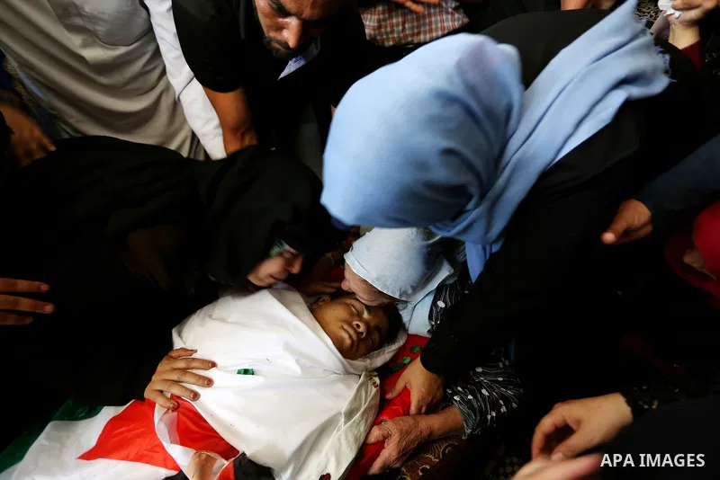 Relatives of Palestinian Mohmen al-Hams, 17, who died of wounds after being shot by Israeli troops during clashes along the border the previous day mourn over his body during his funeral in the Rafah refugee camp in the...