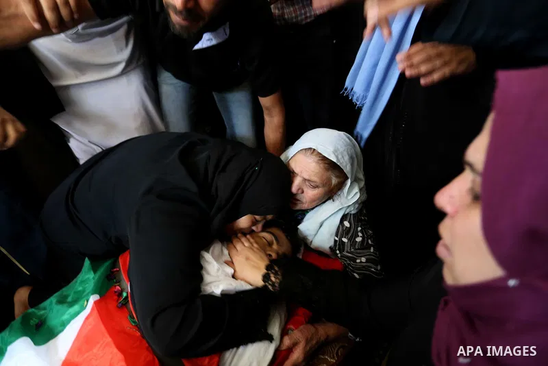 Relatives of Palestinian Mohmen al-Hams, 17, who died of wounds after being shot by Israeli troops during clashes along the border the previous day mourn over his body during his funeral in the Rafah refugee camp in the...