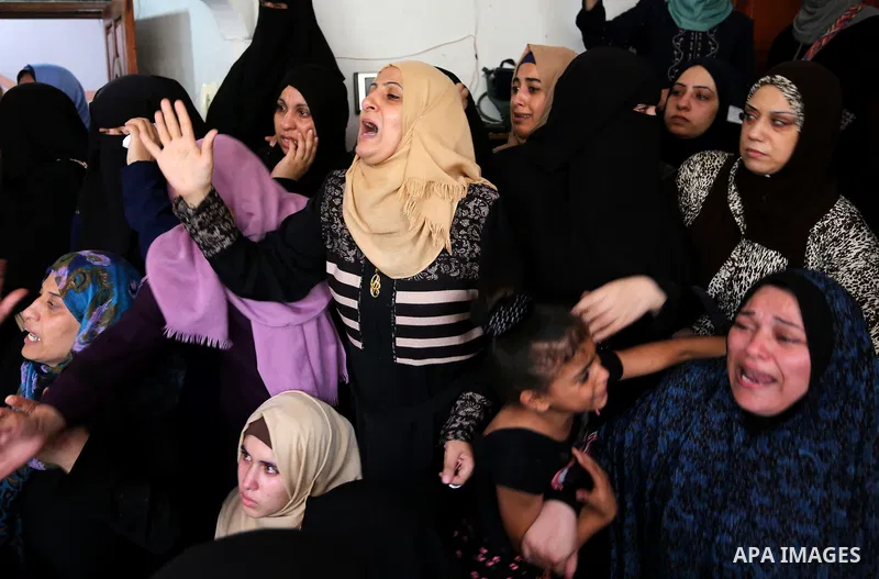 Relatives of Palestinian Mohmen al-Hams, 17, who died of wounds after being shot by Israeli troops during clashes along the border the previous day mourn during his funeral in the Rafah refugee camp in the southern Gaza...