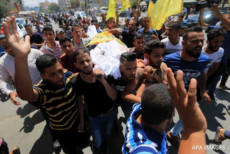 Mourners carry the body of Palestinian Ghazi Abu Mustafa, 43, who was shot dead by Israeli troops during clashes along the border the previous day, carry his body during his funeral in Khan Younis in the southern Gaza St...