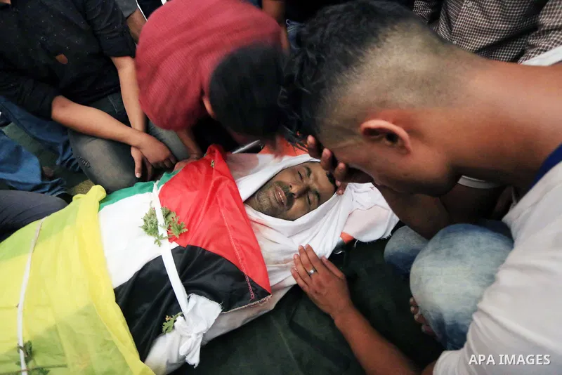 Relatives of Palestinian Ghazi Abu Mustafa, 43, who was shot dead by Israeli troops during clashes along the border the previous day, mourn over his body during his funeral in Khan Younis in the southern Gaza Strip on Ju...