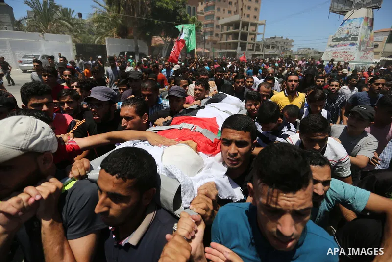 Mourners carry the body of Palestinian Majdi al-Sutari, 11, who was shot dead by Israeli troops during clashes along the border the previous day, during his funeral in Rafah in the southern Gaza Strip on July 28, 2018. P...