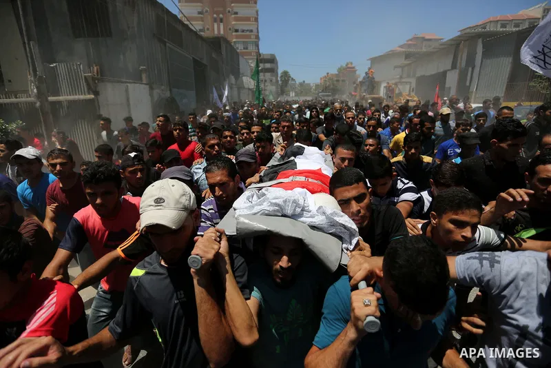 Mourners carry the body of Palestinian Majdi al-Sutari, 11, who was shot dead by Israeli troops during clashes along the border the previous day, during his funeral in Rafah in the southern Gaza Strip on July 28, 2018. P...