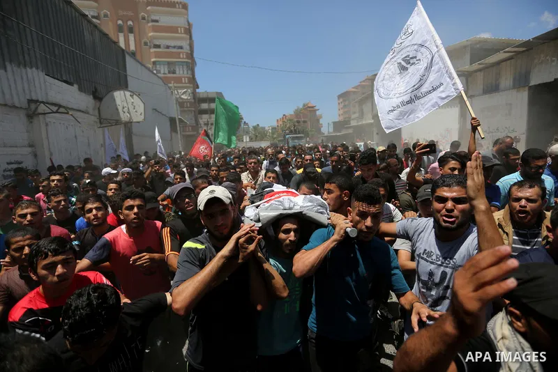 Mourners carry the body of Palestinian Majdi al-Sutari, 11, who was shot dead by Israeli troops during clashes along the border the previous day, during his funeral in Rafah in the southern Gaza Strip on July 28, 2018. P...