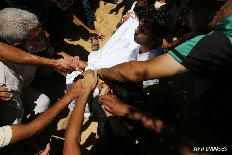 Mourners bury the body of Majdi al-Sutari, 11, who was shot dead by Israeli troops during clashes along the border the previous day, during his funeral in Rafah in the southern Gaza Strip on July 28, 2018. Photo by Ashra...