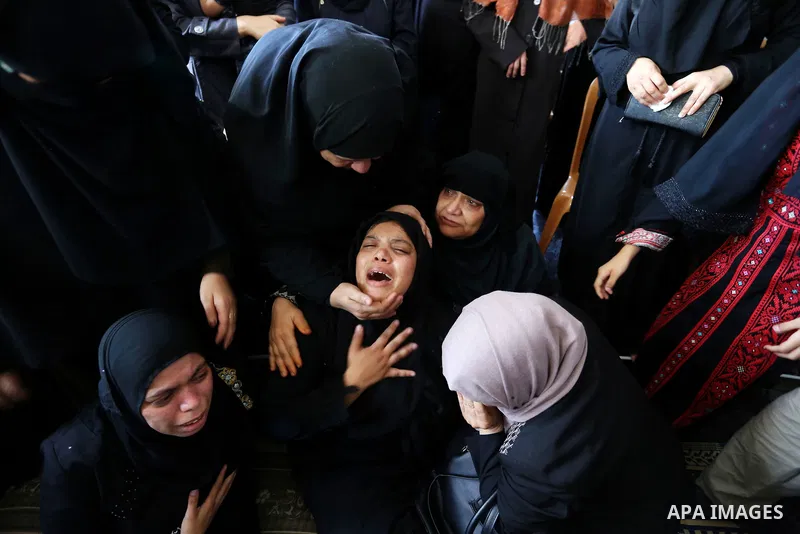 Relatives of Palestinian Mohmen al-Hams, 17, who died of wounds after being shot by Israeli troops during clashes along the border the previous day mourn during his funeral in the Rafah refugee camp in the southern Gaza...