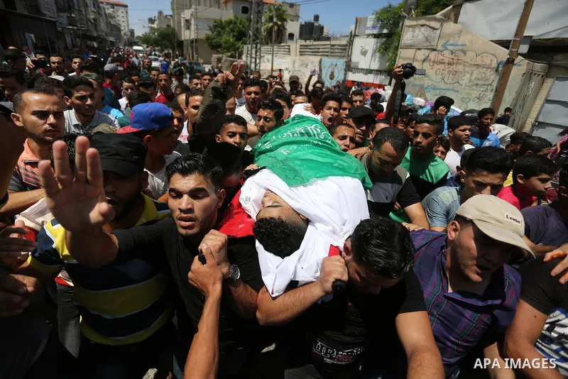 Relatives of Palestinian Mohmen al-Hams, 17, who died of wounds after being shot by Israeli troops during clashes along the border the previous day carry his body during his funeral in the Rafah refugee camp in the south...
