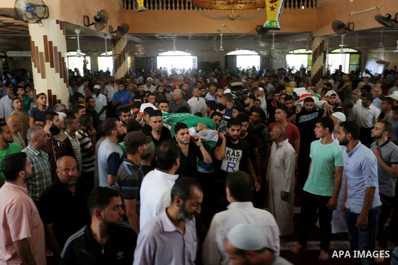 Mourners carry the bodies of Mohmen al-Hams, 17, and Majdi al-Sutari, 11, who were shot dead by Israeli troops during clashes along the border the previous day, during their funeral in Rafah in the southern Gaza Strip on...