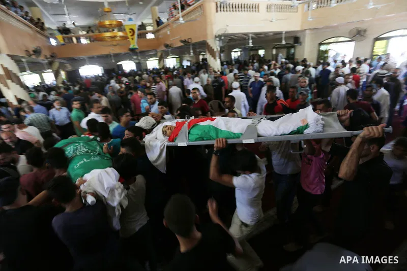 Mourners carry the bodies of Mohmen al-Hams, 17, and Majdi al-Sutari, 11, who were shot dead by Israeli troops during clashes along the border the previous day, during their funeral in Rafah in the southern Gaza Strip on...