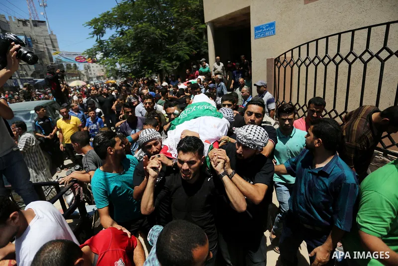 Mourners carry the bodies of Mohmen al-Hams, 17, and Majdi al-Sutari, 11, who were shot dead by Israeli troops during clashes along the border the previous day, during their funeral in Rafah in the southern Gaza Strip on...
