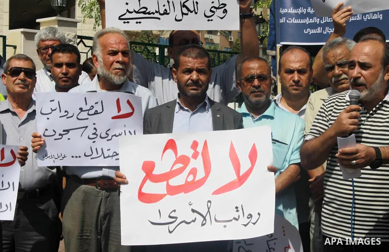 Palestinians take part in a protest to show solidarity with Palestinian prisoners are paid their salaries in Iseali jails in front of the Council of Ministers headcuarter in Gaza City, on July 29, 2018. Photo by Bashar Z...