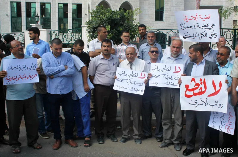 Palestinians take part in a protest to show solidarity with Palestinian prisoners are paid their salaries in Iseali jails in front of the Council of Ministers headcuarter in Gaza City, on July 29, 2018. Photo by Bashar Z...