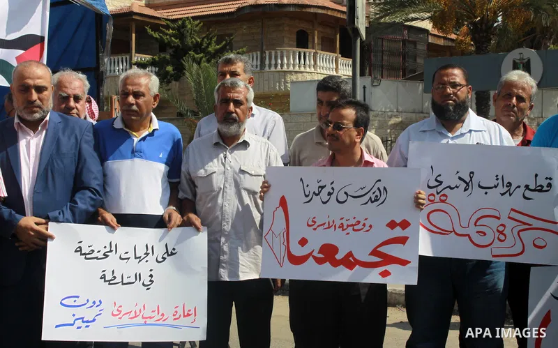 Palestinians take part in a protest to show solidarity with Palestinian prisoners are paid their salaries in Iseali jails in front of the Council of Ministers headcuarter in Gaza City, on July 29, 2018. Photo by Bashar Z...