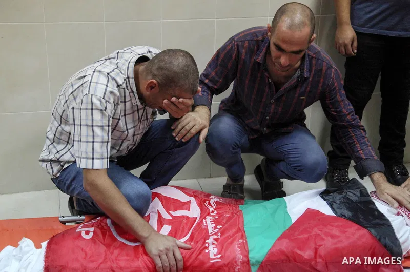 Relatives of two Palestinian who were killed in an unexplained explosion mourn over their bodies during their funeral in Jabalia in the northern of Gaza Strip on July 29, 2018. Photo by Ramez Habboub