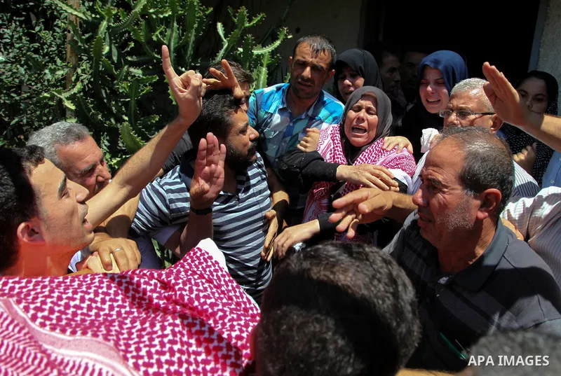 Relatives of two Palestinian who were killed in an unexplained explosion mourn during their funeral in Jabalia in the northern of Gaza Strip on July 29, 2018. Photo by Ramez Habboub