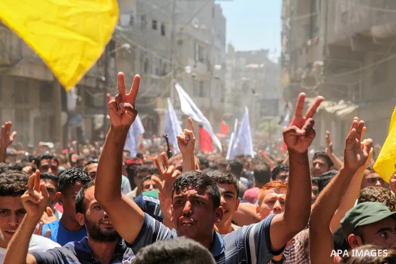 Mourners carry bodies of two Palestinian who were killed in an unexplained explosion during their funeral in Jabalia in the northern of Gaza Strip on July 29, 2018. Photo by Ramez Habboub